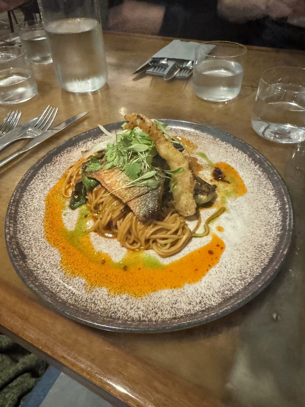 Fish on noodles with an orange sauce